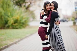 retrato de dois jovens lindos indianos ou adolescentes do sul da Ásia em vestido andando juntos na rua. foto