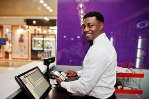 barman americano africano no bar usa um terminal de cartão de crédito no caixa.