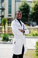 médico americano africano masculino no jaleco com estetoscópio ao ar livre. foto