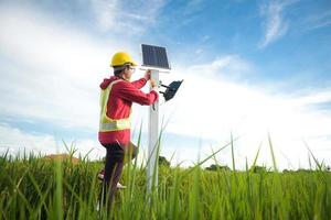 técnico de manutenção durante a instalação de painéis solares fotovoltaicos em terras agrícolas foto