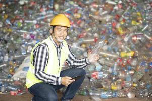 um trabalhador controla a reciclagem de uma usina de reciclagem. garrafas de plástico e resíduos de plástico foto