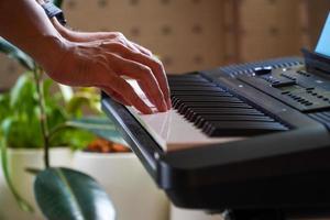 mãos femininas tocando piano .human mãos tocando piano na festa. fêmea tocando teclado sintetizador foto