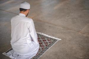 oração do homem islâmico asiático, jovem muçulmano rezando, conceito de festival do ramadã foto