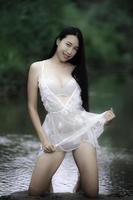 retrato de mulher asiática sexy na cachoeira, sentindo-se fresca no rio, mulher tailandesa relaxa no país foto