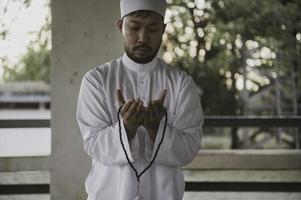 oração do homem islâmico asiático, jovem muçulmano rezando, conceito de festival do ramadã foto