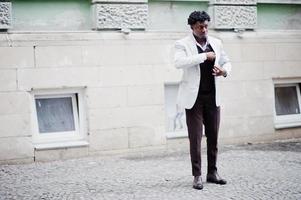 pensativo jovem cavalheiro afro-americano bonito em trajes formais. homem preto elegante modelo de casaco branco. foto