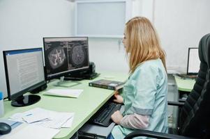 tema médico. médico no escritório de ressonância magnética no centro de diagnóstico no hospital, sentado perto de monitores de computador. foto