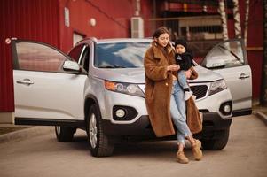 jovem mãe e filho ficam perto do carro suv. conceito de condução de segurança. foto