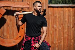 homem barba hipster árabe lenhador segurar machado. foto