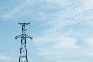 poste de alta tensão de eletricidade no céu azul foto