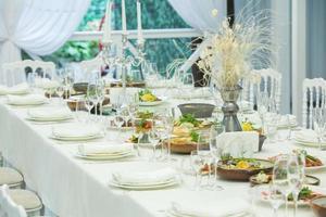 salão de banquetes vazio pronto para receber convidados no terraço de verão. mesa festiva branca foto