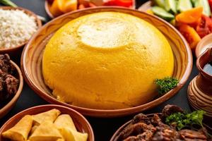 comida romena caseira com polenta, carne, queijo e legumes. delicioso mingau de milho em pratos de barro. mamaliga ou polenta, um prato tradicional na moldávia, Hungria e cozinha ucraniana. foto