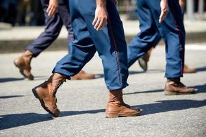 militares marchando em uma rua. pernas e sapatos em linha foto