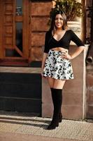 menina bonita modelo latino do Equador usar tops pretos e saia posada na rua. foto