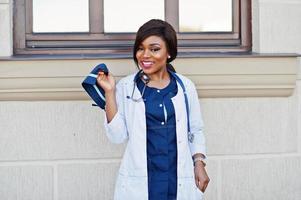 fêmea de médico americano africano com estetoscópio posado ao ar livre. foto