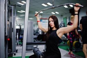 treino de garota esporte jovem no ginásio. mulher fitness fazendo exercícios. foto