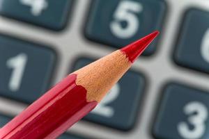 calculadora e caneta vermelha foto