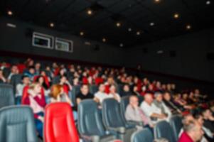 foto borrada de pessoas de audiência no cinema.