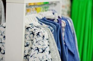 conjunto de roupas coloridas femininas nas prateleiras na loja de roupas nova boutique moderna. foto