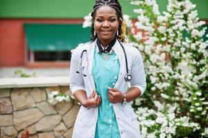 retrato de médica afro-americana com estetoscópio vestindo jaleco. foto
