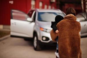 jovem mãe e filho ficam perto do carro suv. conceito de condução de segurança. foto