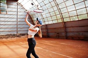 jovem jogador desportivo com raquete de tênis na quadra de tênis. foto