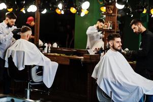 homem barbudo bonito na barbearia, barbeiro no trabalho. foto