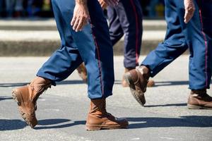 militares marchando em uma rua. pernas e sapatos em linha foto