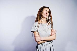 sessão de estúdio de garota de vestido cinza com dreads em fundo branco. foto