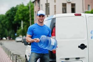entregadores na van de carga da frente entregando garrafas de água. foto