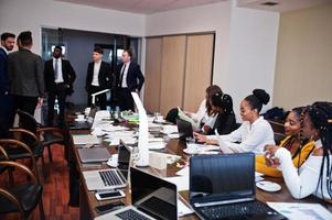 equipe de negócios multirracial abordando a reunião em torno da mesa da diretoria. foto