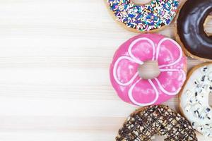 rosquinhas sortidas com cobertura de chocolate, cobertura polvilha rosquinhas variedade colorida e variedade de sabores mistura de rosquinhas doces multicoloridas com fosco polvilhado sobre fundo azul. foto