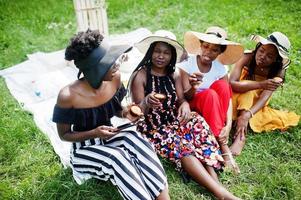 grupo de garotas afro-americanas comemorando festa de aniversário e comem muffins ao ar livre com decoração. foto