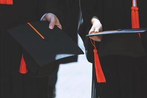 tiro de chapéus de formatura durante graduados de sucesso de início da universidade, parabéns pela educação do conceito. cerimônia de formatura, parabenizou os graduados na universidade durante o início. foto