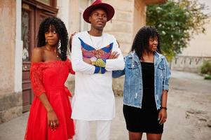 grupo de três amigos elegantes na moda afro frança posou no dia de outono. modelo de homem negro africano com duas mulheres de pele escura. foto
