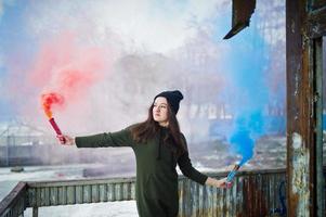 jovem com bomba de fumaça colorida azul e vermelha nas mãos. foto