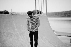 modelo de homem de barba árabe alto bonito na camisa despojada posou ao ar livre. cara árabe na moda em óculos de sol. foto