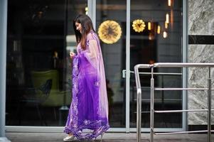 garota hindu indiana no saree violeta tradicional posou na rua. foto