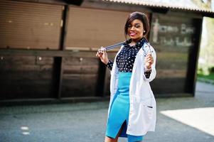 fêmea de médico americano africano com estetoscópio posado ao ar livre. foto