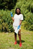 mulher voluntária africana com prancheta no parque. áfrica voluntariado, caridade, pessoas e conceito de ecologia. foto