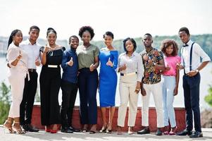 grupo de dez afro-americanos posaram na rua da cidade. pessoas elegantes da África mostra o polegar para cima. foto