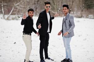 grupo de três casuais jovens indianos posaram em dia de inverno se divertindo e dançando. foto