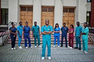 grupo de estudantes de medicina africanos posou ao ar livre contra a porta da universidade. foto