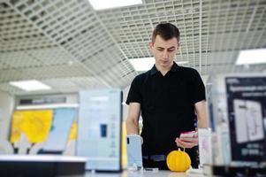 vendedor homem consultor profissional de telefonia móvel na loja de tecnologia ou loja mantenha o novo smartphone à mão. foto