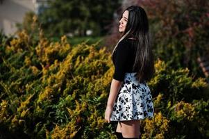 menina bonita modelo latino do Equador usar tops pretos e saia posada na rua. foto