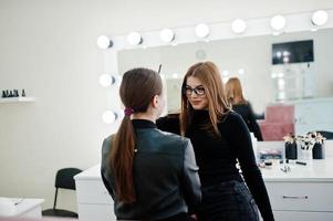 maquiadora trabalha em seu salão de beleza. mulher aplicando pelo mestre de maquiagem profissional. conceito de clube de beleza. foto