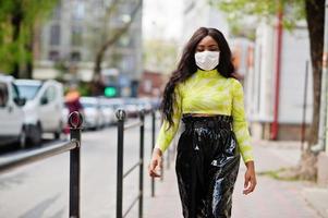 mulher afro-americana posando com máscara facial para proteger contra infecções de bactérias, vírus e epidemias. foto