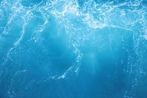 ondas do mar na onda do mar espirrando água da ondulação. fundo de água azul. foto