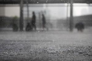 chuva cai na água pesada na sombra do asfalto da sombra preta e reflexo do céu escuro na cidade. alto contraste durante o outono foto