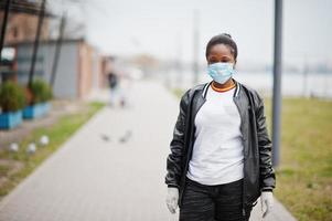 garota africana no parque usando máscaras médicas protege contra infecções e doenças quarentena de vírus coronavírus. foto